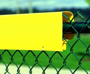 Yellow Safety Top Cap on a Green Chain Link Fence